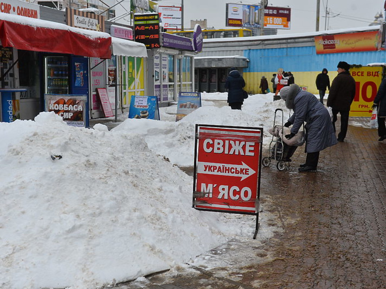 Снег в Киеве убирают дворники с лопатами и водители со щетками, техники почти не видно