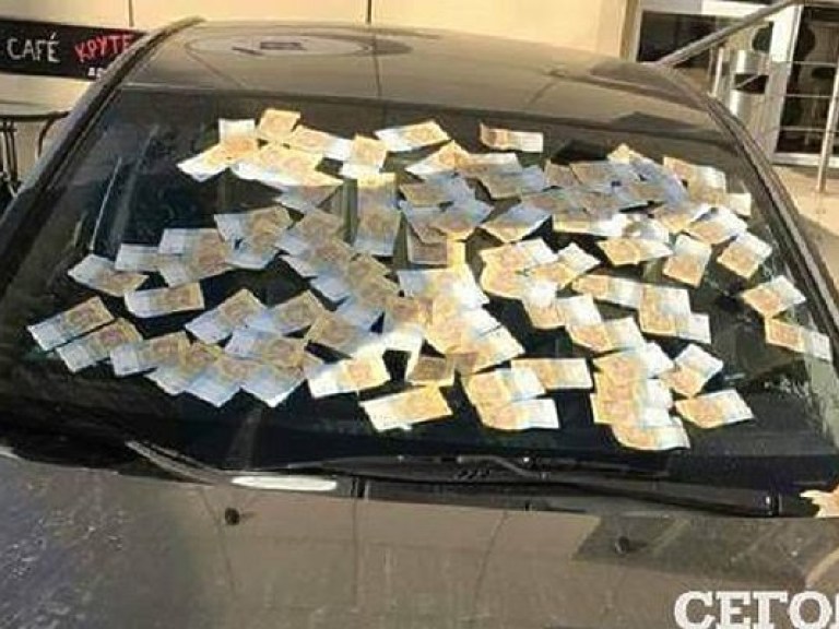 В Киеве лобовое стекло автомобиля полностью заклеили деньгами