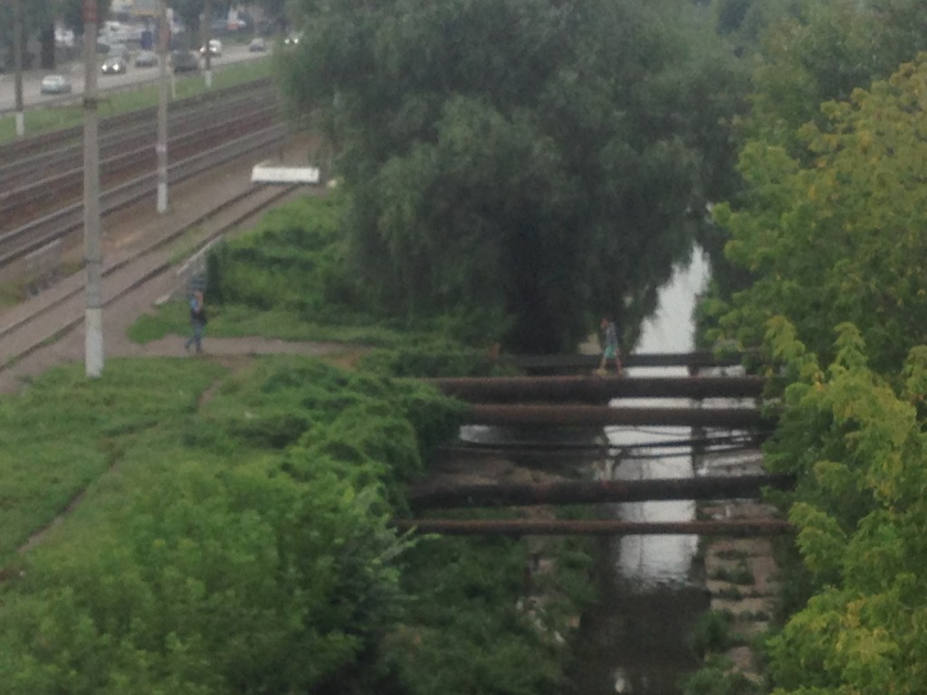 В Киеве из поврежденного моста пешеходы вынуждены заниматься «эквилибристикой» на трубе (ФОТО)