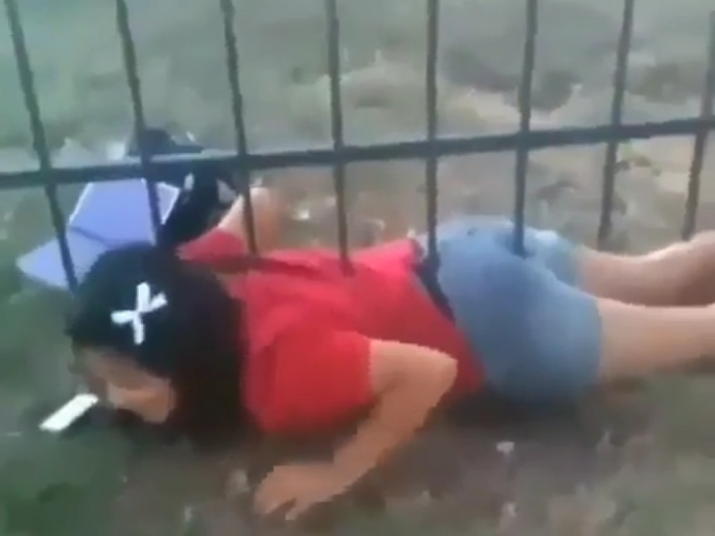 Девушка намертво застряла под острым забором в попытке под ним пролезть (ВИДЕО)