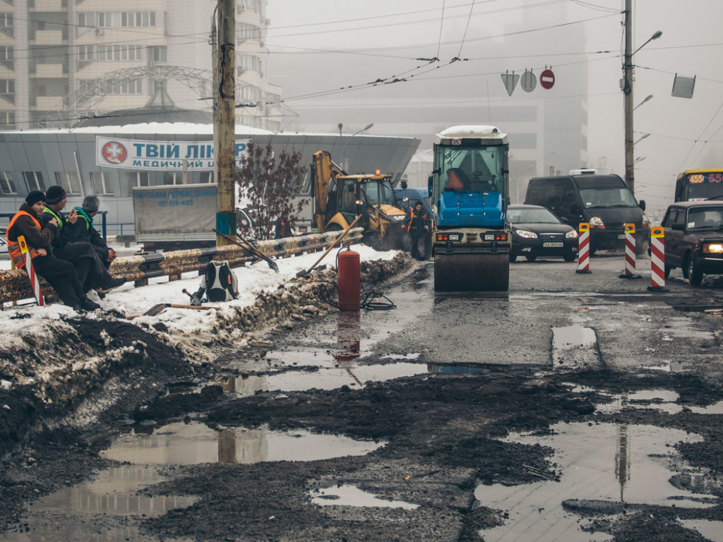 В Киеве ямы на Шулявском мосту в дождь засыпали асфальтом (ФОТО, ВИДЕО)