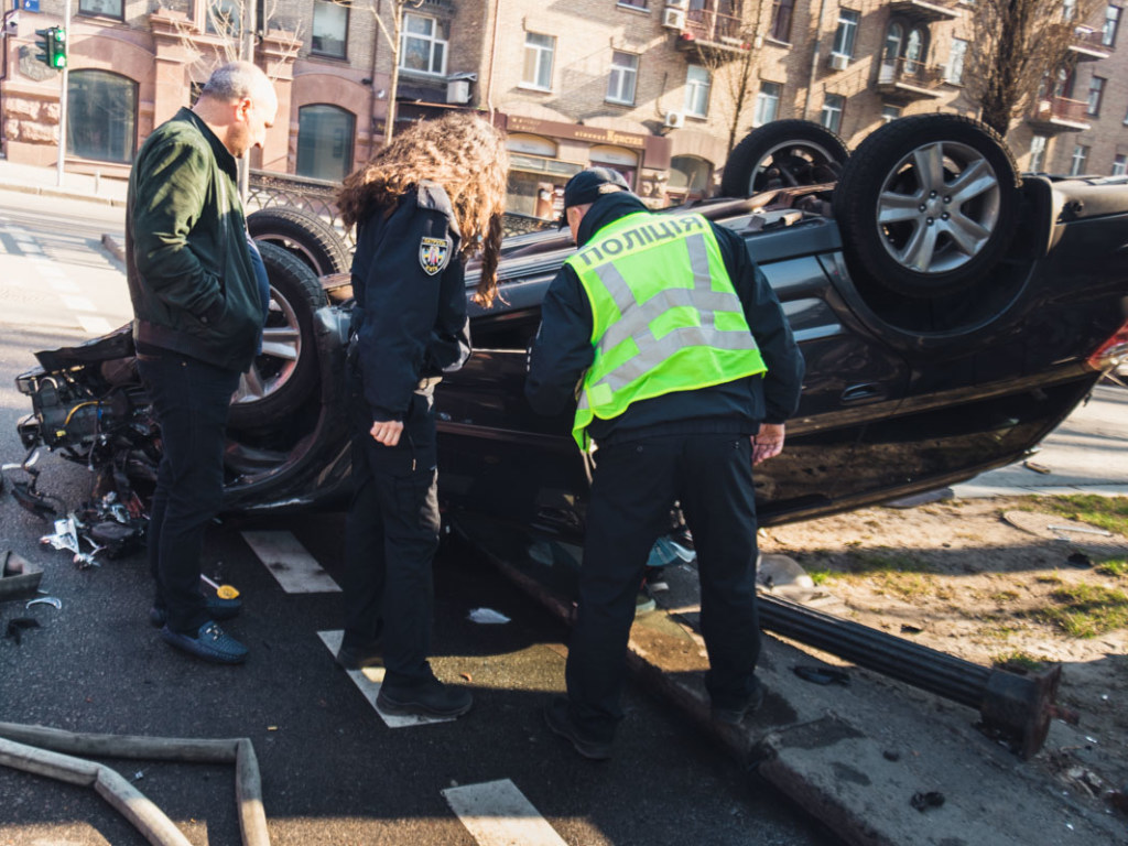 В центре Киева столкнулись две иномарки: Subaru снес забор и перевернулся (ФОТО, ВИДЕО)