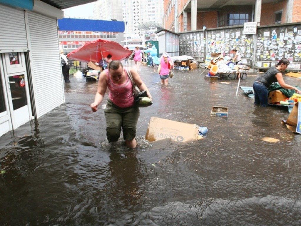На столичной Шулявке затопило улицу: горожане идут по колено в воде (ВИДЕО)