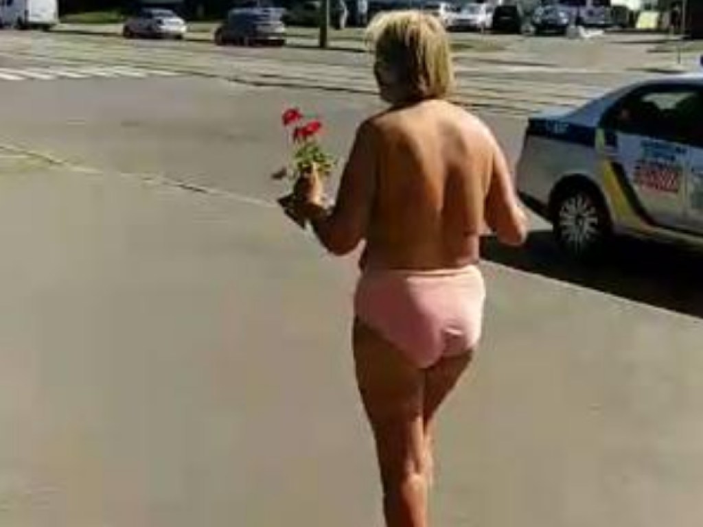 В трусах без бюстгальтера: по Киеву гуляла полуголая пенсионерка с цветами (ФОТО)