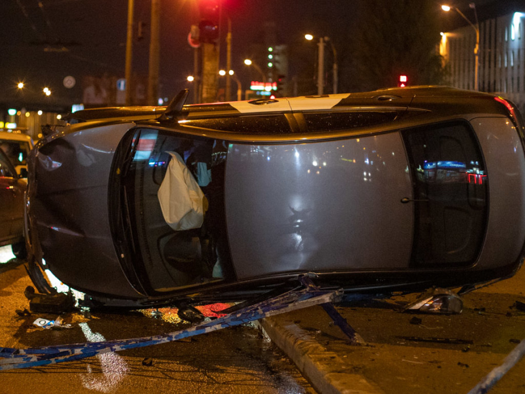 Машина перевернулась: В Киеве автомобиль такси свалил 15-метровый забор (ФОТО, ВИДЕО)