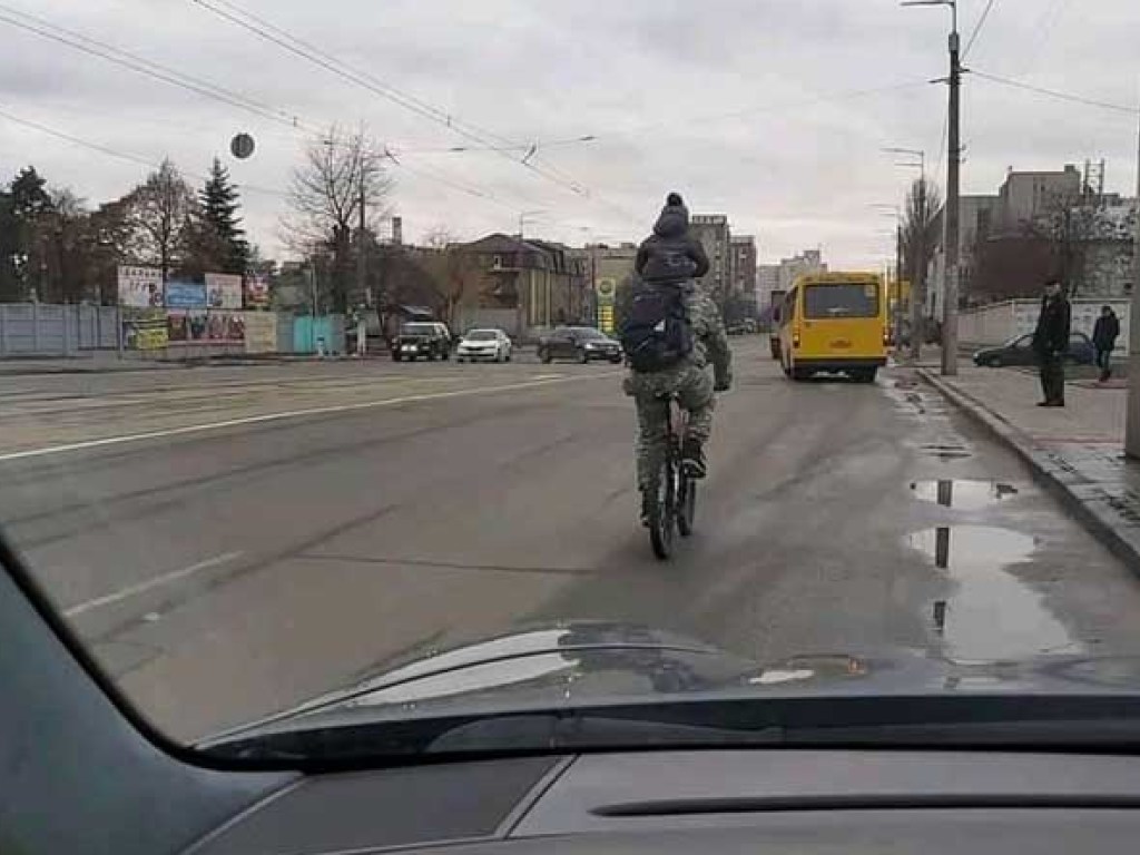 На Новой Дарнице в Киеве на дороге увидели «акробата» на велосипеде с ребенком на плечах (ФОТО)