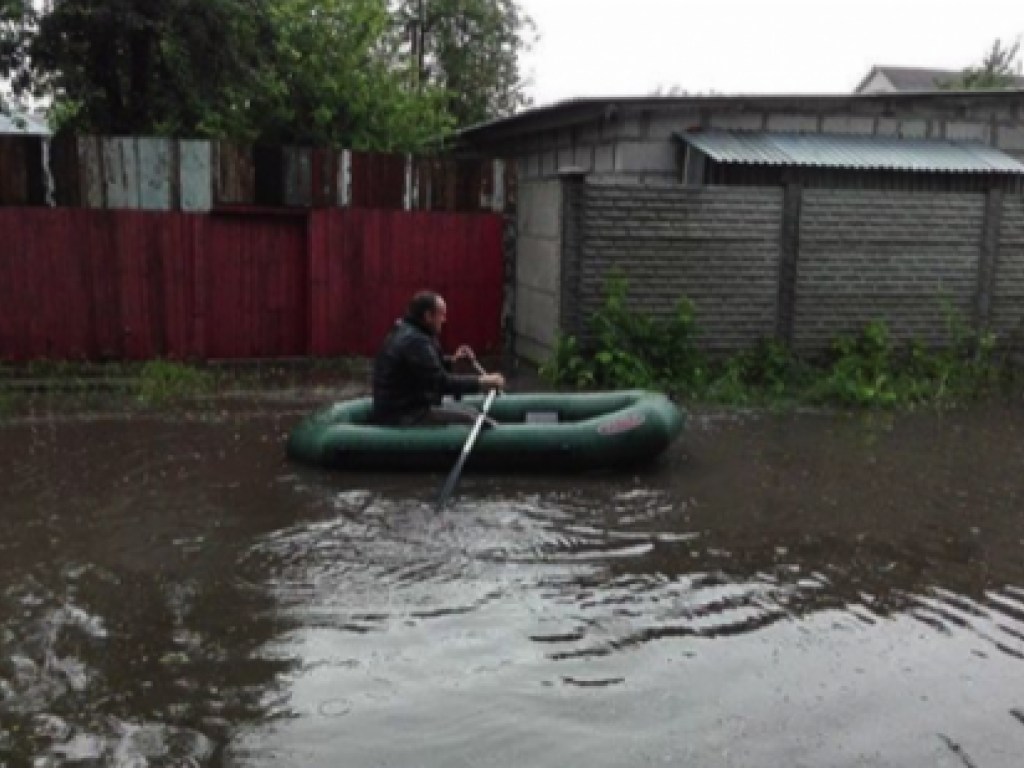 Мужчина плыл по улице на лодке: В Харькове во время ливневого дождя затопило улицы (ФОТО)