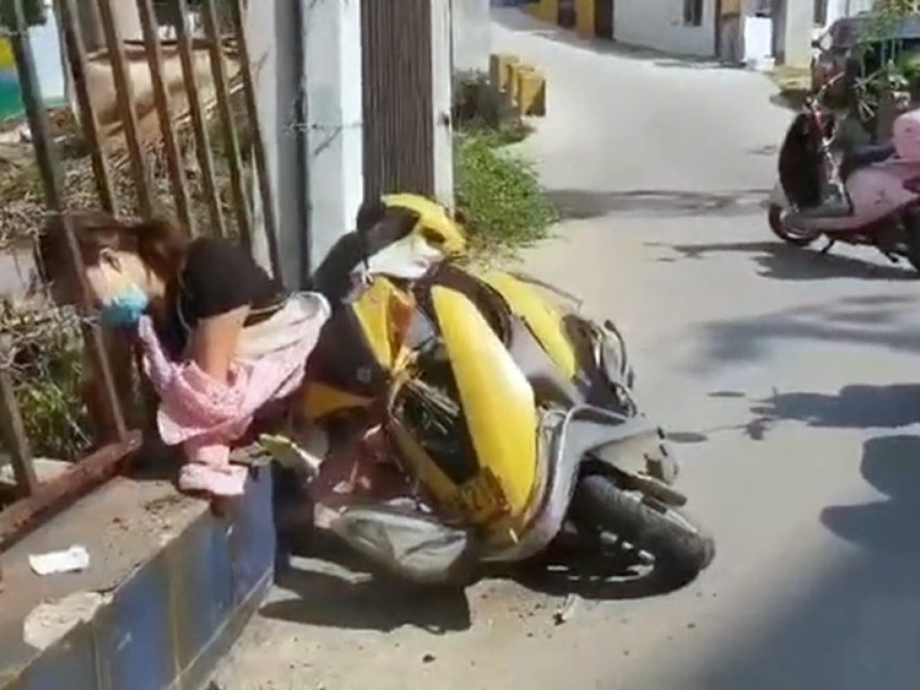 В Китае женщина упала со скутера и застряла головой в заборе (ФОТО)