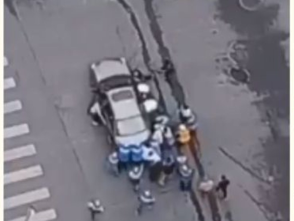 В Китае группа курьеров перенесла автомобиль ради спасения велосипедистки (ФОТО)